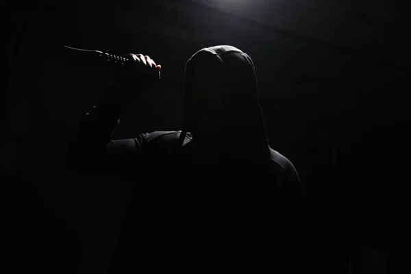 Silhouette of bandit with knife in lighting isolated on black - foto de stock