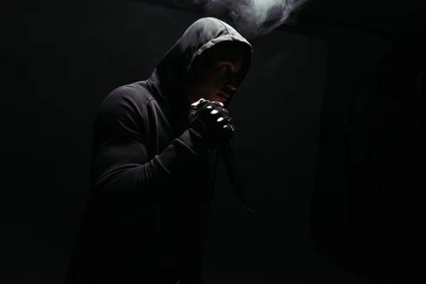 Silhouette of african american bandit holding knife on black background with smoke - foto de stock