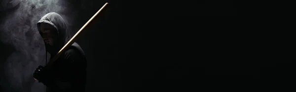 Side view of silhouette of african american hooligan with baseball bat on black background with smoke, banner — Stockfoto