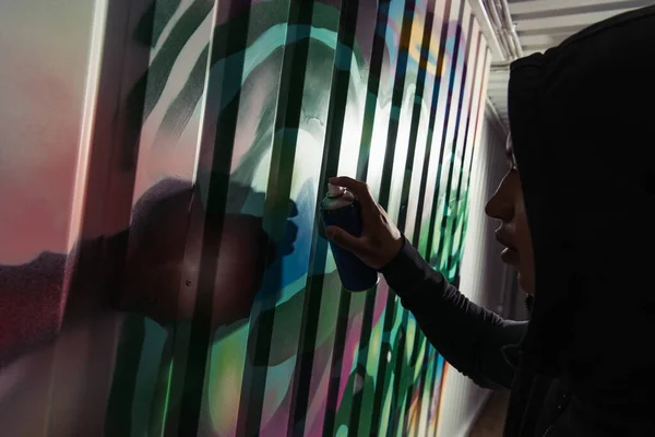 Side view of african american vandal drawing graffiti on wall — Stock Photo