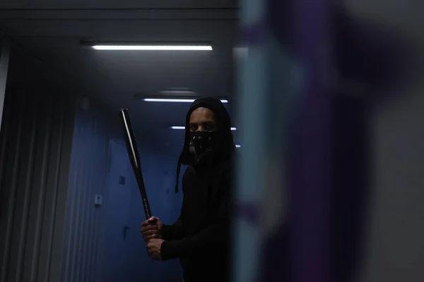 African american vandal holding baseball bat near wall in garage — Stock Photo