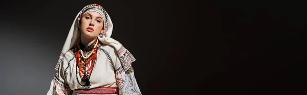 Giovane donna ucraina in abiti tradizionali con ornamento e perline rosse su nero, banner — Foto stock