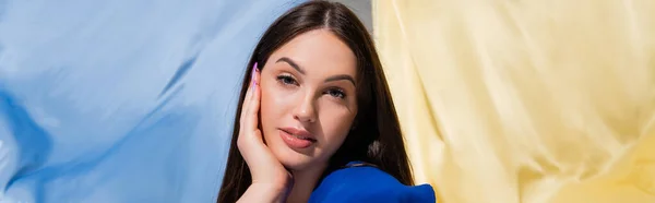 Pretty young ukrainian woman posing near blue and yellow flag, banner — Stock Photo