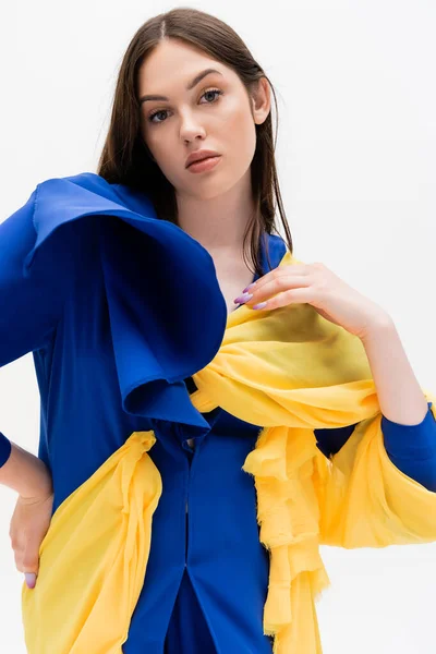 Confident ukrainian woman in blue and yellow outfit looking at camera isolated on white — Stock Photo