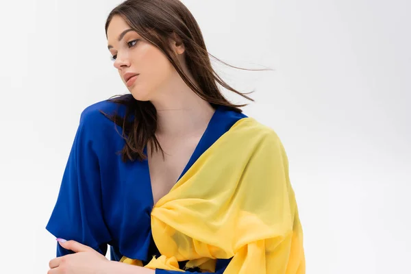 Patriotic ukrainian young woman in blue and yellow outfit looking away isolated on grey — Photo de stock