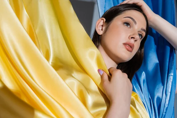 Retrato de mulher ucraniana morena posando perto da bandeira nacional azul e amarela — Fotografia de Stock