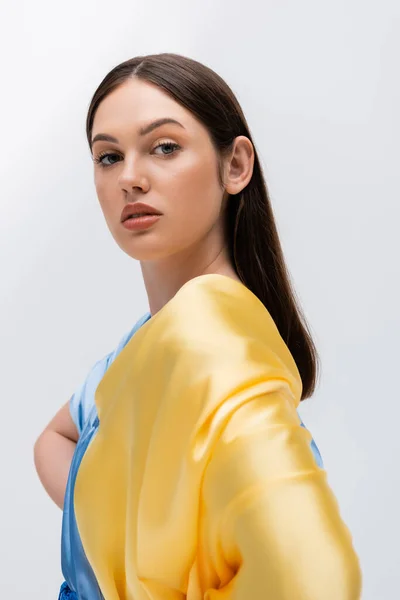 Портрет нежной украинки в голубой и желтой одежде, смотрящей на камеру, изолированную на сером — стоковое фото