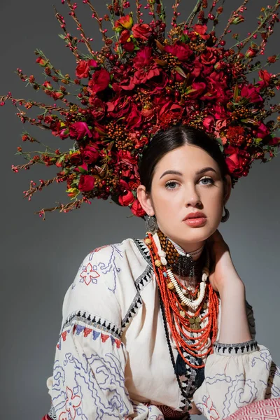 Portrait of pretty ukrainian woman in traditional clothing and floral red wreath with berries isolated on grey — Photo de stock