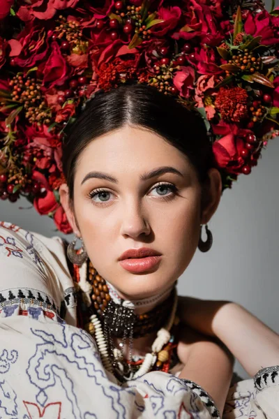 Portrait de jolie femme ukrainienne en couronne rouge florale avec des baies isolées sur gris — Photo de stock