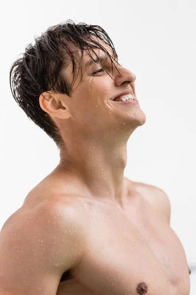 Мокрий і веселий чоловік зі спортивним тілом і ідеальною шкірою ізольовані на білому — стокове фото