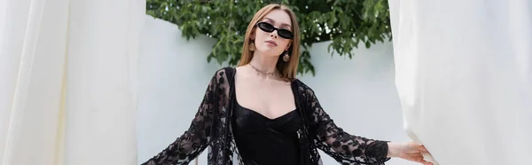 Stylische Frau in Badeanzug und Sonnenbrille mit Vorhängen im Resort, Banner — Stockfoto