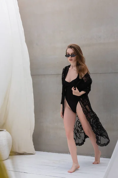 Stylische Frau in Badebekleidung und Sonnenbrille spaziert im Resort — Stockfoto