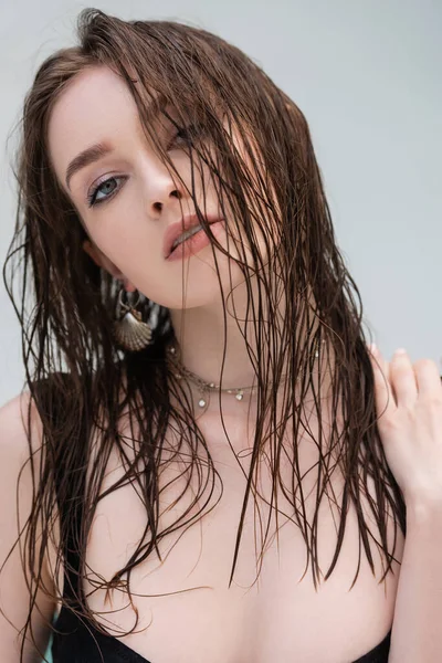 Jovem na moda com cabelo molhado olhando para a câmera ao ar livre — Fotografia de Stock