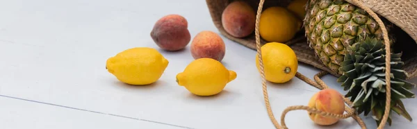 Tropical fruits in straw handbag on floor at resort, banner — стоковое фото