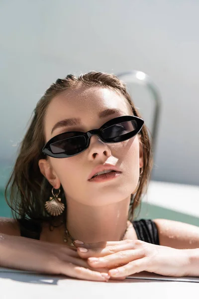 Portrait of young and stylish woman in black sunglasses — Stockfoto