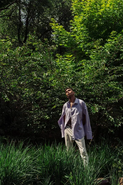 Fashionable african american man posing with closed eyes in summer park — Stockfoto