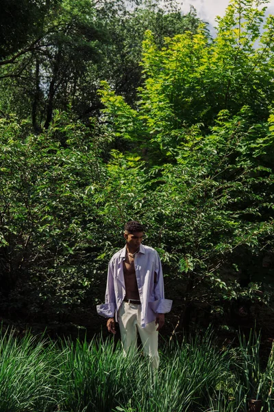 Молодий афроамериканський чоловік в модному літньому вбранні, що стоїть в парку — стокове фото
