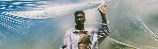 Blurred american man behind cellophane film outdoors, banner — Stock Photo