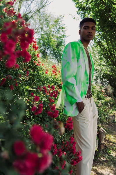 African american man in stylish autumn clothes posing in park on blurred foreground — стоковое фото