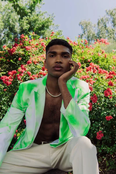 Young african american man in trendy white and green blazer looking at camera in park — Stock Photo