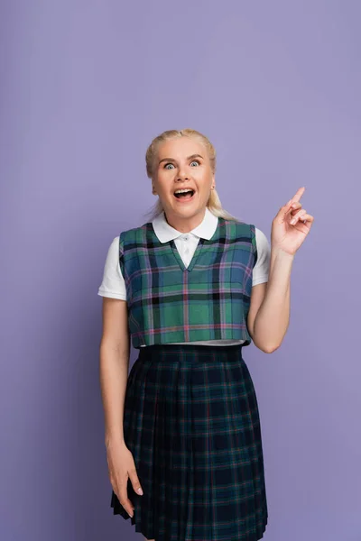 Excited student in checkered vest pointing with finger isolated on purple — Foto stock