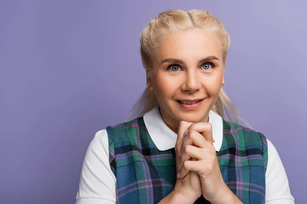 Portrait of blonde student with clenched hands looking at camera isolated on purple — Photo de stock