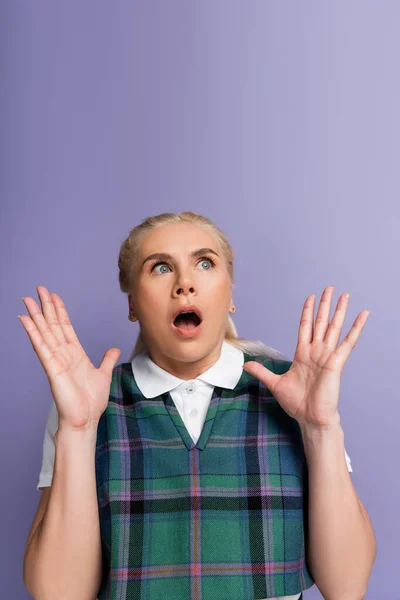 Scared blonde student looking away isolated on purple — Stock Photo
