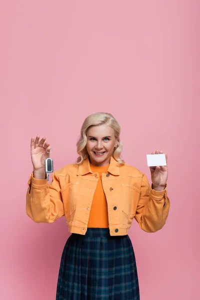 Happy woman holding driving license and car key isolated on pink — Stock Photo