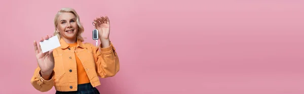 Blurred woman holding driving license and car key isolated on pink, banner — Stockfoto