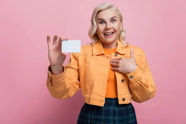 Amazed blonde woman holding empty driving license isolated on pink — Photo de stock