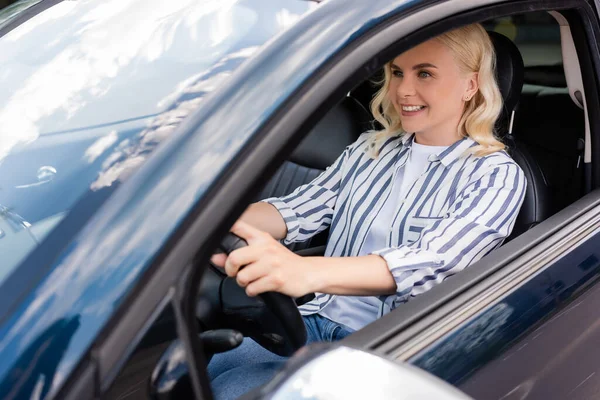 Positive woman sitting in car during driving courses — стоковое фото