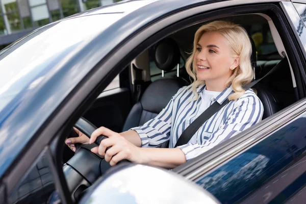 Cheerful woman looking away during driving courses in car — стоковое фото