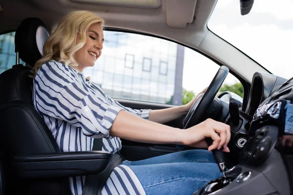 Cheerful blonde beginner driving car during course — Stock Photo