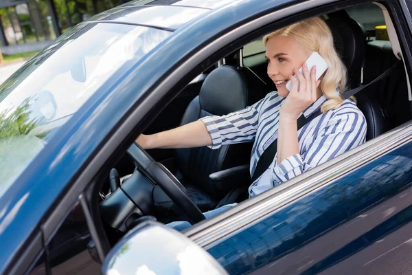 Позитивний водій розмовляє на мобільному телефоні під час водіння автомобіля — стокове фото