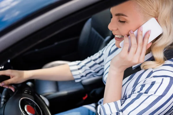Усміхнена жінка розмовляє на мобільному телефоні під час курсу водіння в авто — стокове фото