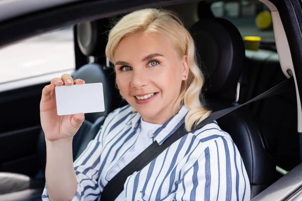 Cheerful woman holding driver license in auto — Photo de stock