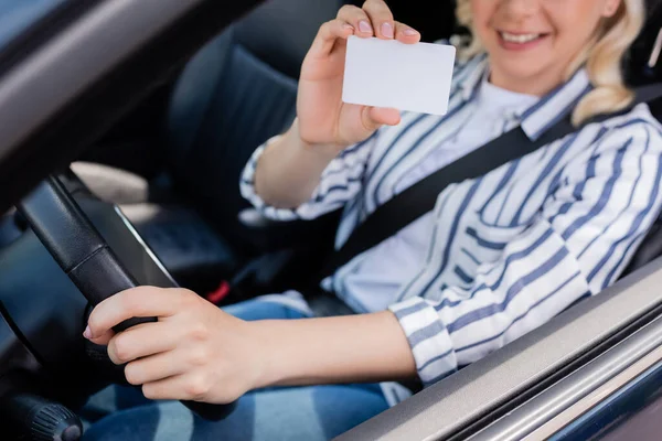 Cropped view of blurred woman holding driving license in car - foto de stock