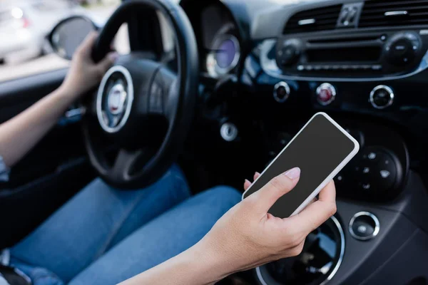 Cropped view of smartphone with blank screen in hand of driver in car — Stock Photo