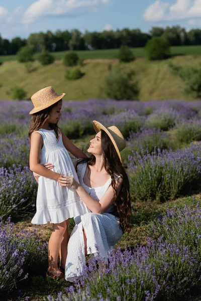 Happy mother and child in white dresses looking at each other in lavender field — Photo de stock