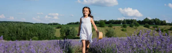 Girl with straw hat walking in lavender field on summer day, banner — Foto stock