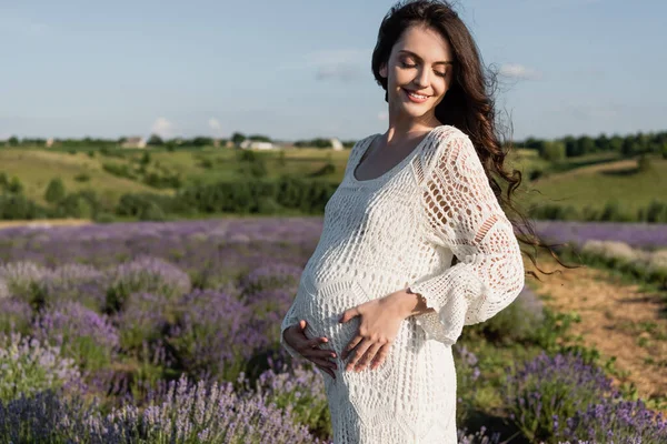 Happy pregnant woman in white dress in summer lavender field — Fotografia de Stock