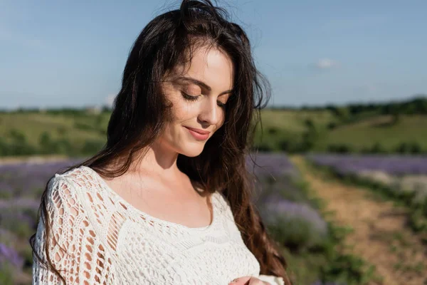 Pretty woman with long brunette hair smiling outdoors — Fotografia de Stock