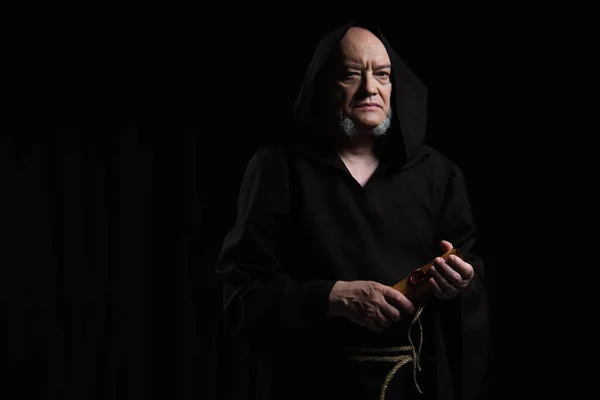 Medieval monk in cassock holding parchment with wax seal isolated on black — Stock Photo