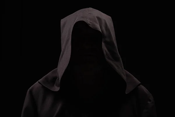 Таинственный анонимный монах в темном капюшоне, изолированный от черного — стоковое фото