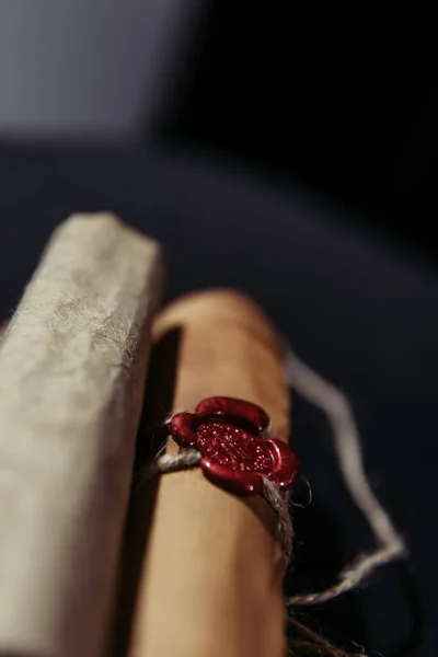 Close up view of wax seal on ancient manuscript near rolled parchments on dark background — Stock Photo