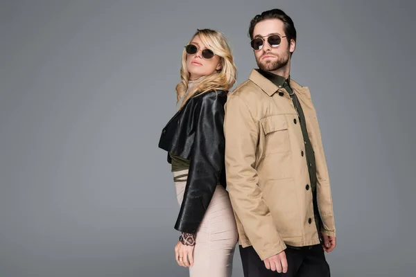 Blonde woman and bearded man in sunglasses posing together isolated on grey — Stockfoto