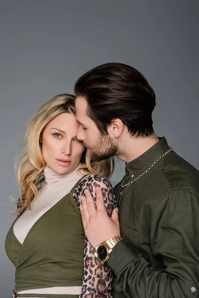 Bearded man in green shirt hugging blonde girlfriend isolated on grey — Stock Photo