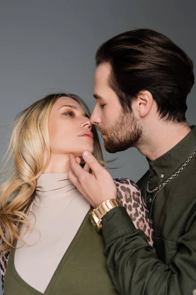 Bearded man in green shirt kissing blonde girlfriend isolated on grey — Photo de stock