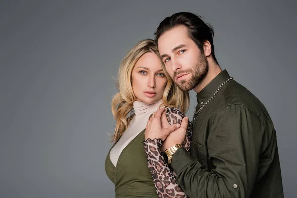 Bearded man in green shirt hugging blonde girlfriend isolated on grey — Photo de stock