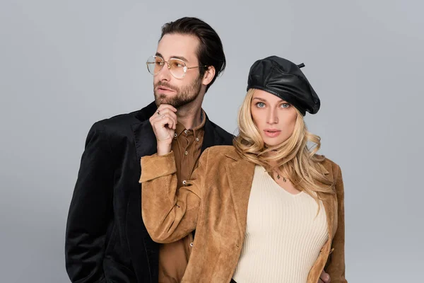 Blonde woman in stylish beret near bearded man in sunglasses isolated on grey — Foto stock